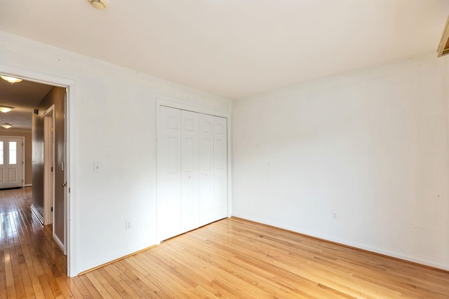 unfurnished bedroom with light wood-type flooring and a closet