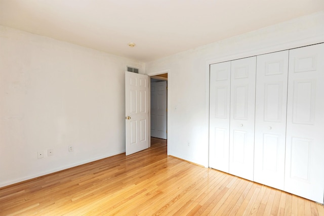 unfurnished bedroom featuring light hardwood / wood-style floors and a closet