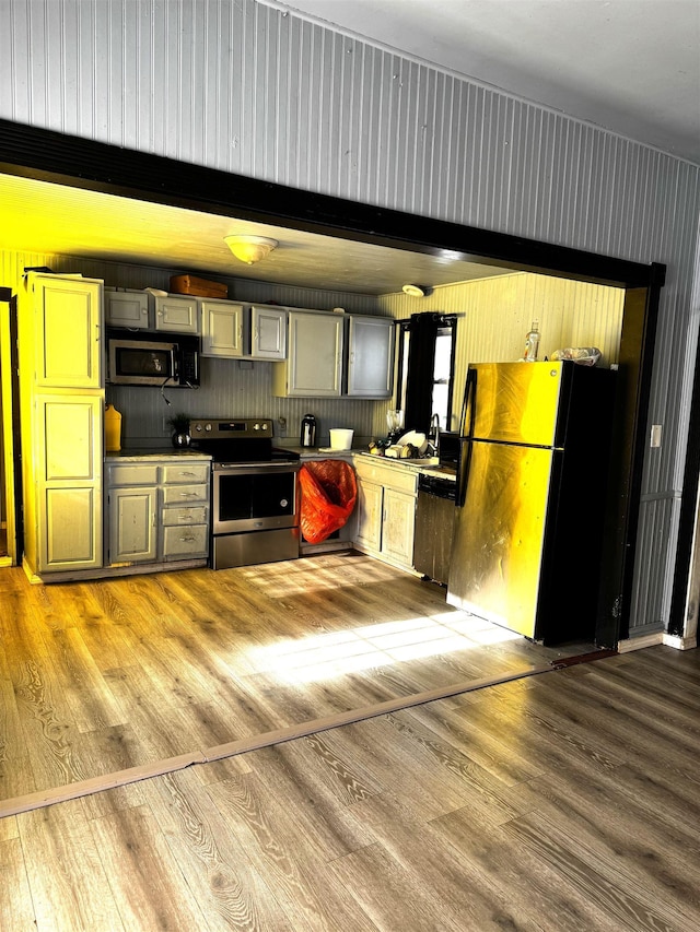 kitchen with light hardwood / wood-style floors, gray cabinetry, and stainless steel appliances