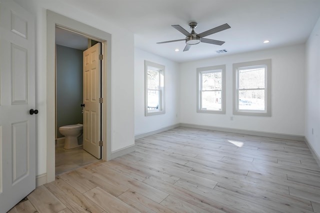 unfurnished bedroom featuring ceiling fan, ensuite bathroom, and light hardwood / wood-style flooring