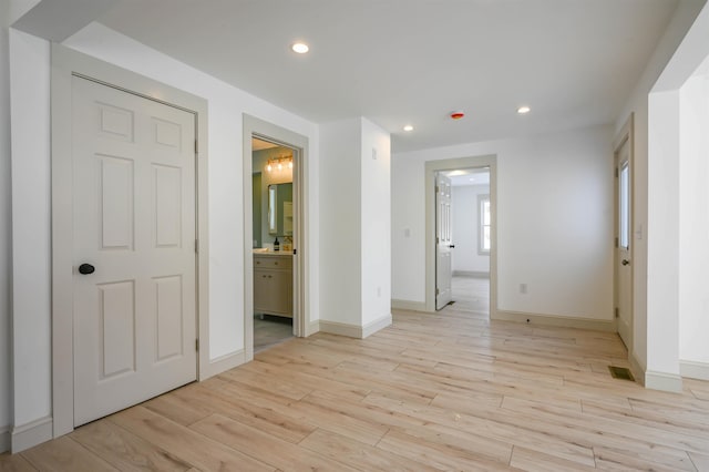 unfurnished bedroom featuring light wood-type flooring and connected bathroom