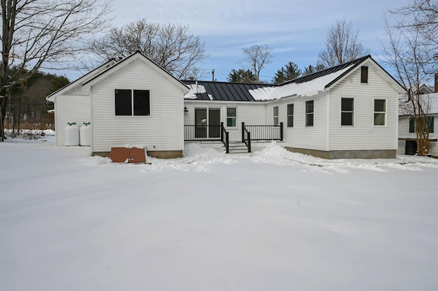 view of snow covered rear of property