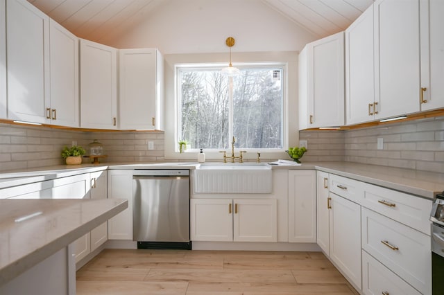 kitchen featuring white cabinets, vaulted ceiling, and dishwasher