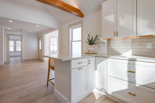 kitchen with white cabinets, decorative backsplash, vaulted ceiling with beams, and wood ceiling