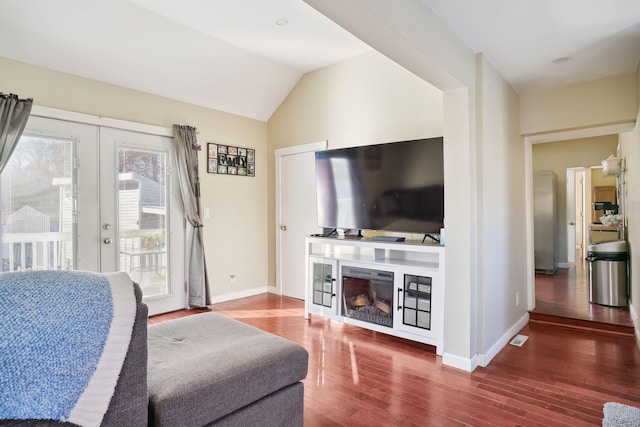 living room with dark hardwood / wood-style floors, french doors, and vaulted ceiling