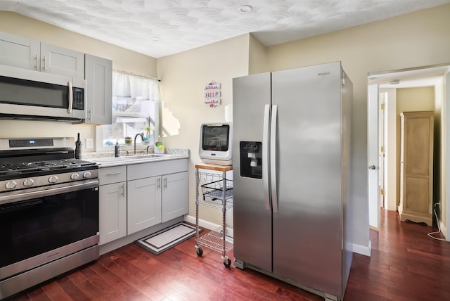 kitchen featuring sink, dark hardwood / wood-style flooring, white cabinets, and stainless steel appliances