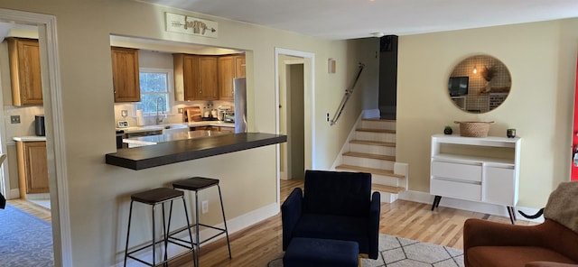 kitchen featuring sink, a kitchen bar, and light hardwood / wood-style floors