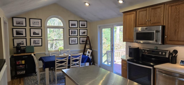 kitchen with dark wood-type flooring, decorative backsplash, lofted ceiling, and stainless steel appliances