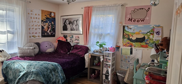 bedroom with wood-type flooring and multiple windows