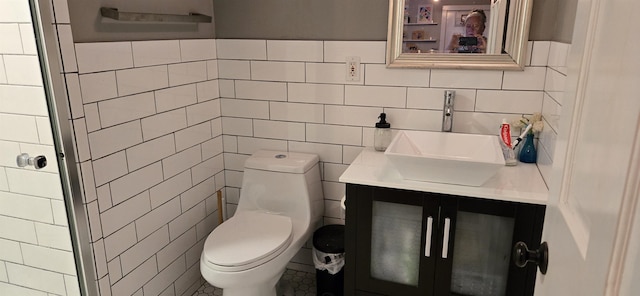 bathroom featuring vanity, toilet, and tile walls