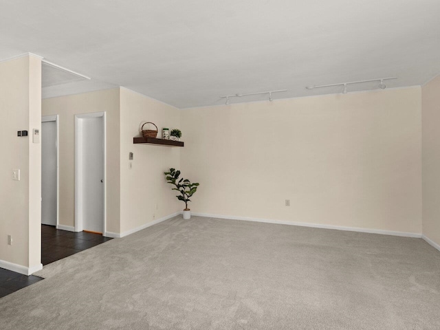 carpeted spare room with track lighting