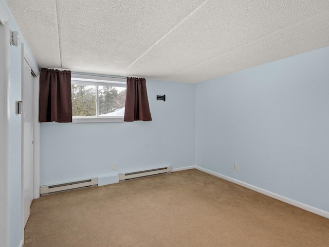 carpeted spare room with a baseboard radiator and a textured ceiling