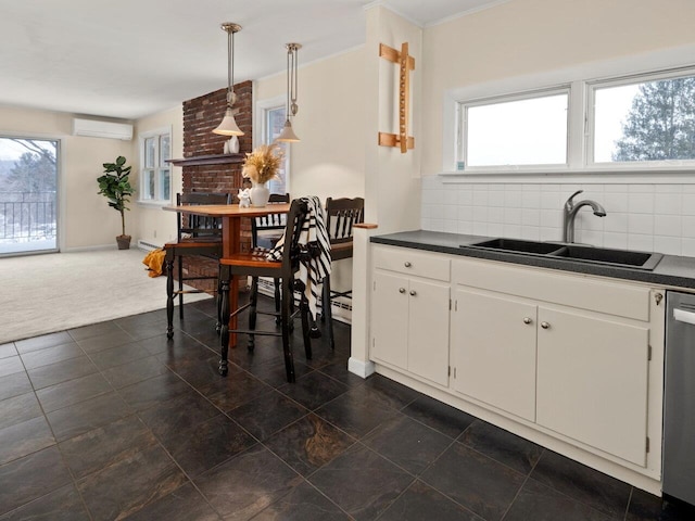 kitchen with a wall mounted air conditioner, decorative light fixtures, white cabinetry, sink, and dark colored carpet