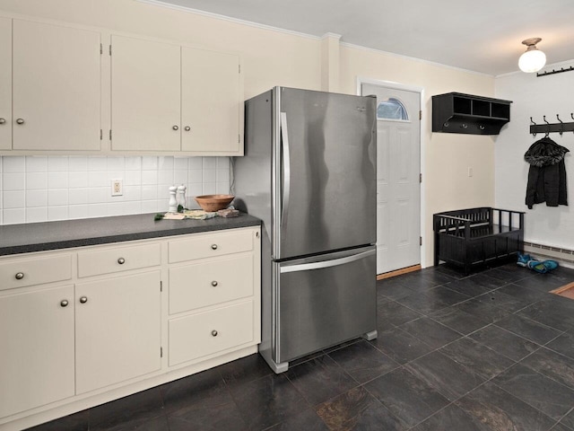 kitchen with crown molding, stainless steel fridge, baseboard heating, tasteful backsplash, and white cabinets