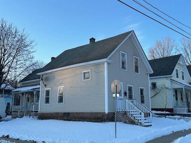 snow covered property with a porch