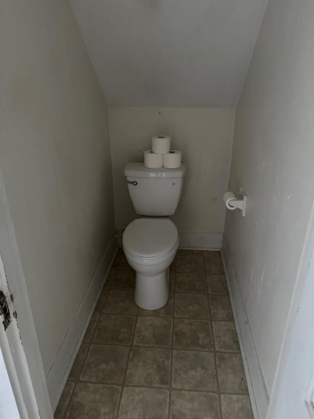 bathroom with toilet and lofted ceiling