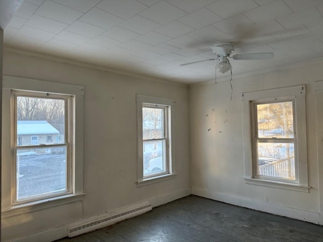 empty room featuring ceiling fan, a baseboard heating unit, and ornamental molding