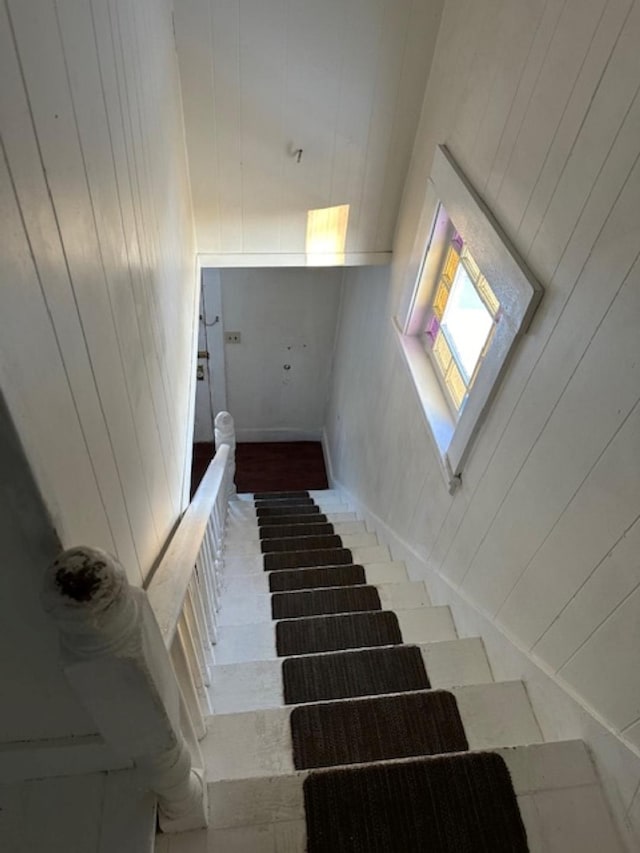 stairway with a high ceiling and wooden walls