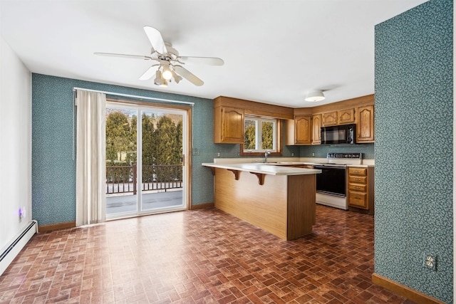 kitchen featuring white range with electric cooktop, baseboard heating, kitchen peninsula, ceiling fan, and a kitchen bar