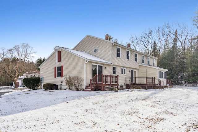 snow covered rear of property featuring a wooden deck