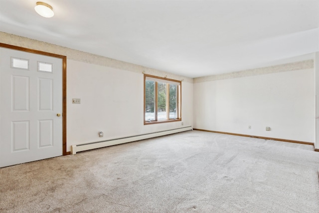 carpeted spare room featuring a baseboard heating unit