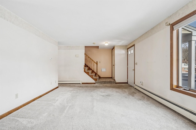 carpeted spare room featuring a wealth of natural light and baseboard heating