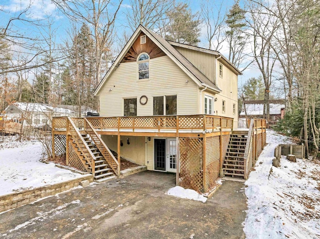 snow covered house featuring a wooden deck