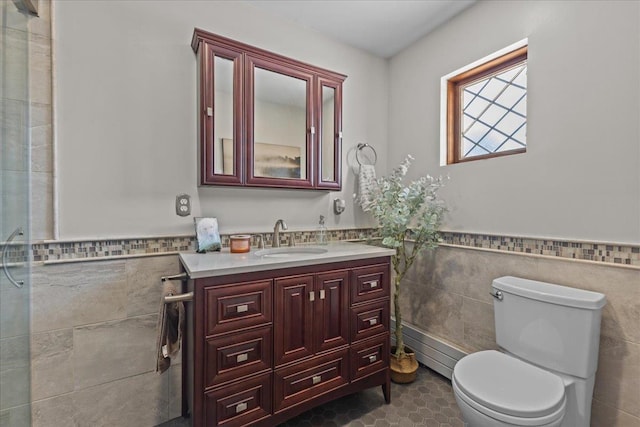 bathroom featuring toilet, vanity, tile patterned floors, and tile walls