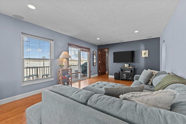 living room with light wood-type flooring and a textured ceiling