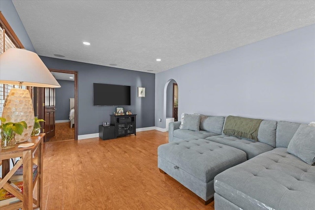 living room with wood-type flooring and a textured ceiling