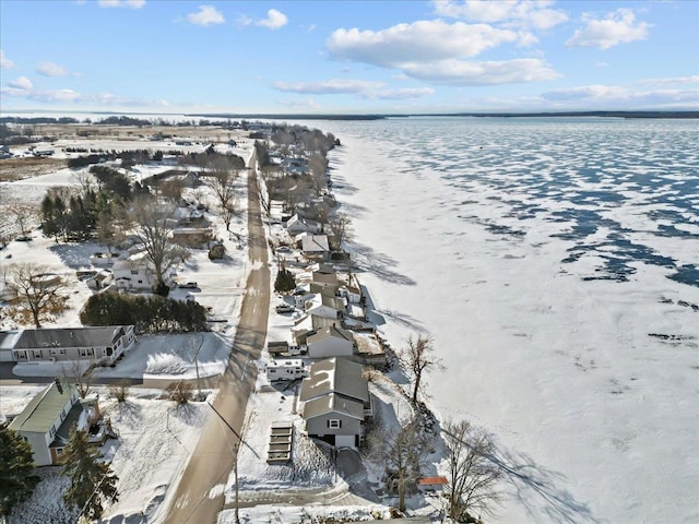 snowy aerial view featuring a water view