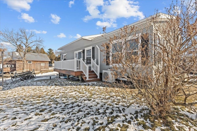 view of snowy exterior featuring a wooden deck