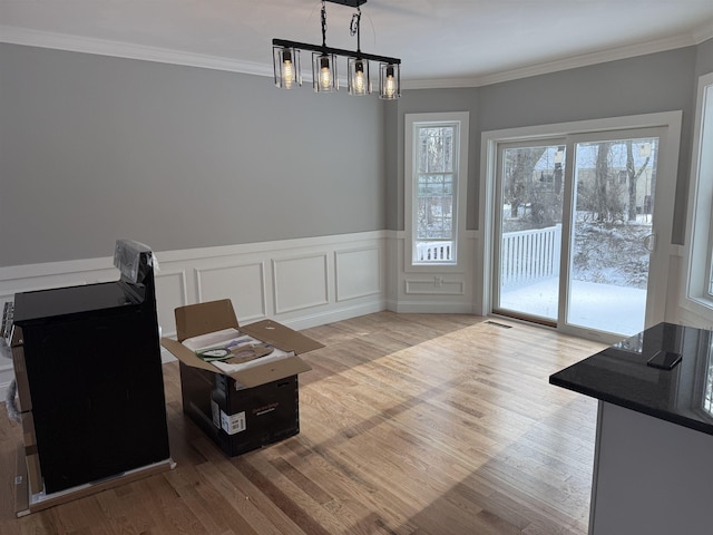 unfurnished room featuring crown molding, a notable chandelier, and light hardwood / wood-style flooring