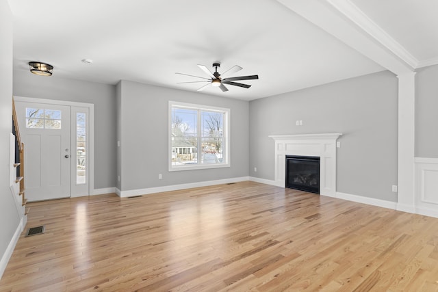 unfurnished living room featuring plenty of natural light, ceiling fan, and light hardwood / wood-style flooring