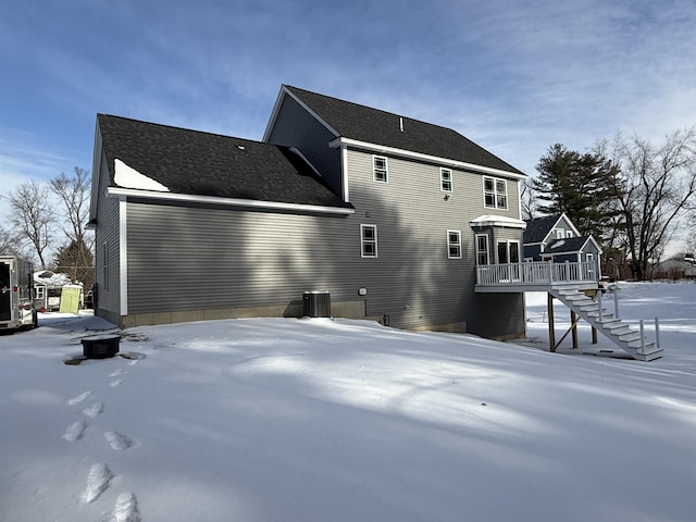 snow covered back of property featuring a wooden deck and cooling unit