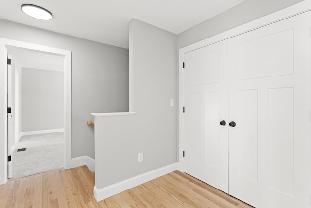 hallway with hardwood / wood-style flooring