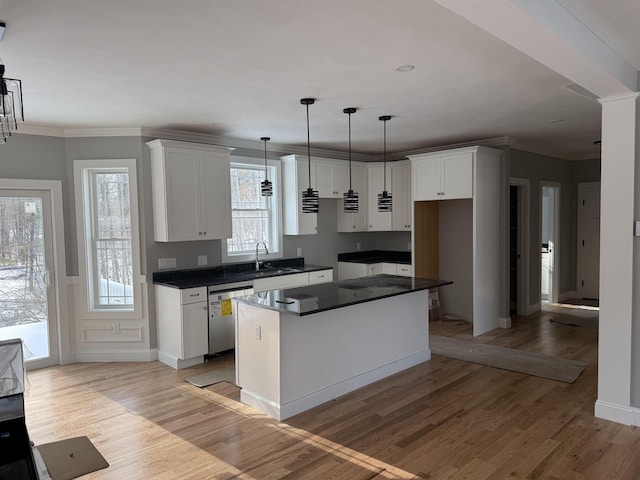 kitchen with stainless steel dishwasher, light hardwood / wood-style flooring, a kitchen island, and white cabinets