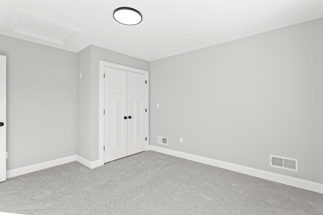 unfurnished bedroom featuring light colored carpet and a closet