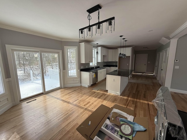 kitchen with white cabinetry, crown molding, a center island, hanging light fixtures, and light hardwood / wood-style floors