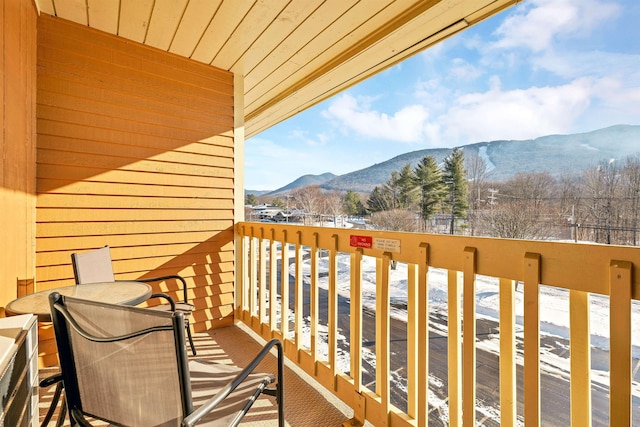 snow covered back of property featuring a mountain view