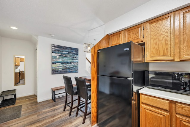 kitchen featuring dark wood-type flooring and black fridge