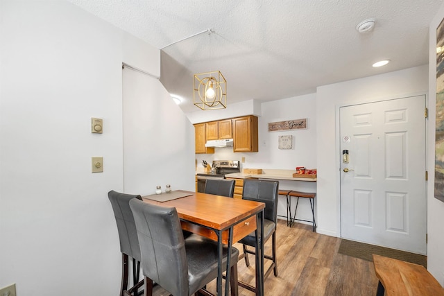 dining space featuring hardwood / wood-style flooring and a textured ceiling