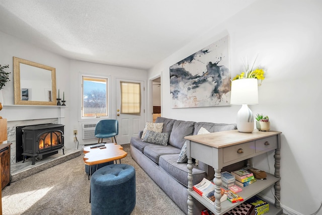 carpeted living room with a textured ceiling, a wall unit AC, and a fireplace