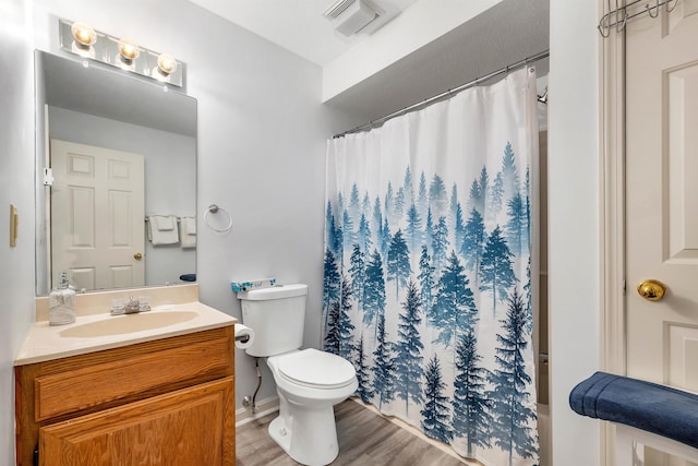 bathroom with hardwood / wood-style flooring, toilet, a shower with shower curtain, and vanity