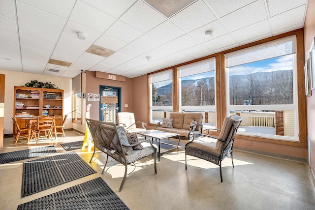 living room featuring plenty of natural light and a paneled ceiling