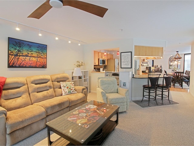 living room with light carpet, ceiling fan, and track lighting