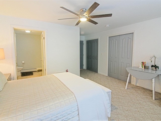 bedroom with a baseboard heating unit, ceiling fan, light colored carpet, two closets, and ensuite bath