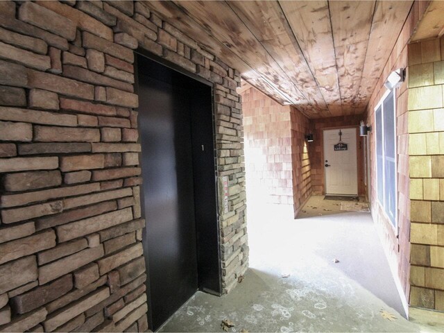 hallway with wooden ceiling and wood walls