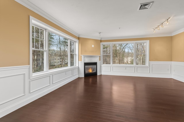 unfurnished living room featuring ornamental molding and dark hardwood / wood-style flooring