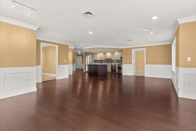 unfurnished living room featuring rail lighting, dark hardwood / wood-style flooring, and crown molding